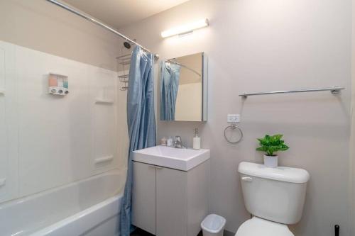 a bathroom with a toilet and a sink and a shower at McCormick Place 2br-2ba with Optional Parking, Patio, Gym access for 6 guests in Chicago