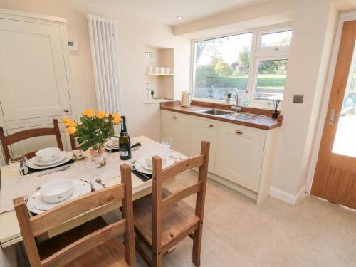 a kitchen with a table and chairs and a sink at Appletree Cottage in Scarborough