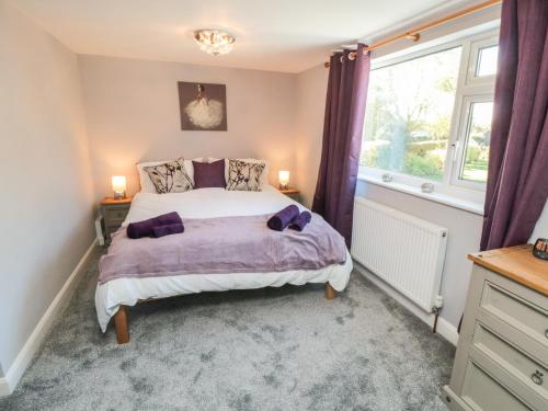 a bedroom with a large bed and a window at Appletree Cottage in Scarborough