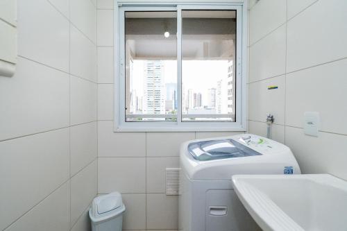 baño blanco con lavabo y ventana en THE EXPRESSION BUENO en Goiânia