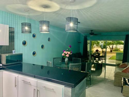 een keuken met een blauwe muur met hanglampen bij Sand Dollar Apartment B11 Serenity By The Sea in Kralendijk