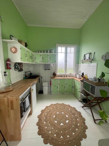 a kitchen with green cabinets and a rug on the floor at Avalon II in Innisfail
