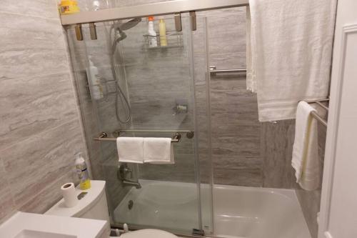 a bathroom with a shower with a toilet and a sink at Handsome Home - 4 minutes close to Metro in Lanham