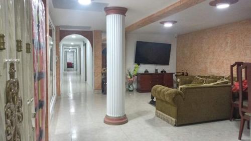 a living room with two couches and a column at Hotel Velices in Buga