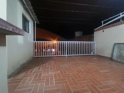 Habitación con suelo de ladrillo y valla blanca en departamento céntrico y confortable, en Tarija
