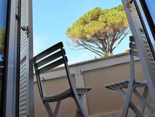 a chair sitting on top of a roof with a tree at Room Eufemija-Rab in Rab