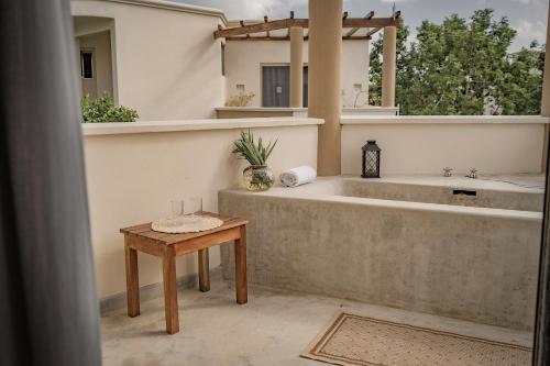 a bathroom with a bath tub and a table at Boutique Hotel Posada 06 Tulum in Tulum