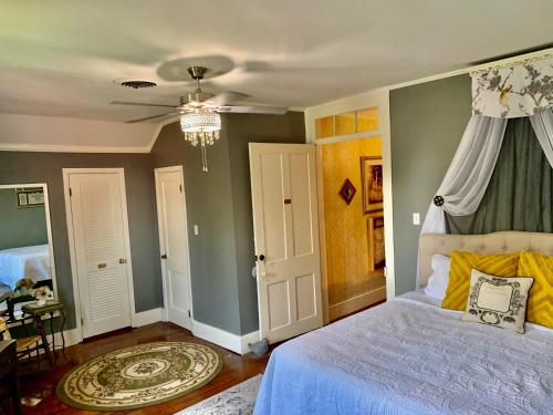 a bedroom with a bed and a chandelier at The Beaumont House Natchez in Natchez