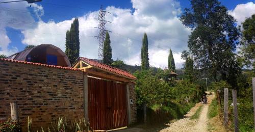 a brick building next to a road with trees at Glamping VILLA - Nueva en Paipa in Paipa