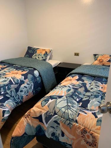 dos camas sentadas una al lado de la otra en un dormitorio en Cabañas y Departamentos Las Palmas, Temuco Depto 4, en Temuco