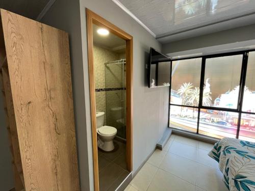 ein Badezimmer mit einem WC und einer Glastür in der Unterkunft DOÑA EMMA in Sibundoy