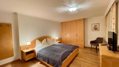 a bedroom with a bed and a desk and a television at Ferienhaus Anger in Bad Hofgastein