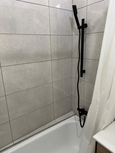 La salle de bains est pourvue d'une douche et d'une baignoire blanche. dans l'établissement Le Marceau, T2 tout équipé au cœur de ville, à Grenoble