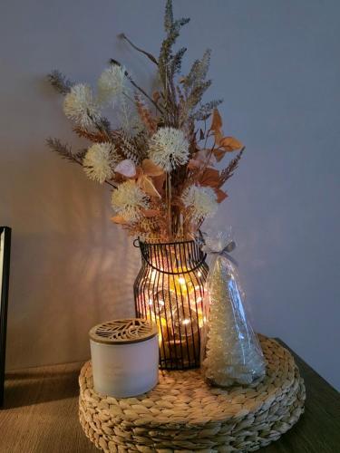 a vase with flowers and a candle on a table at bloom_apartman in Zlatibor