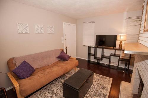 a living room with a couch and a flat screen tv at Hip & Cozy to Explore the City or Catch a Game in Pittsburgh