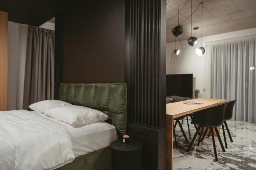 a bedroom with a bed and a desk with a computer at 26Bricks Luxury Suites in Oradea