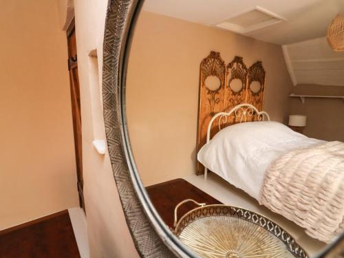 een spiegel in een slaapkamer met een bed en een bed. bij 4 Cumberland Cottages in Kingsbridge