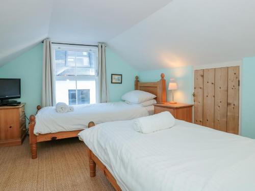 a bedroom with two beds and a tv and a window at 19 Above Town in Dartmouth