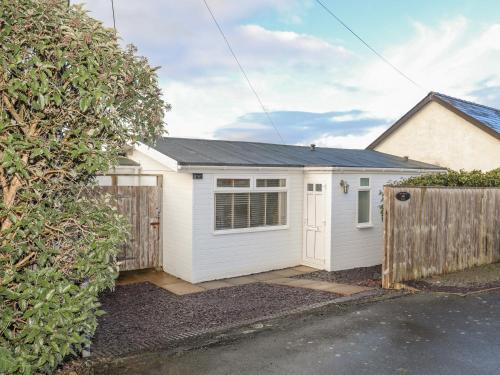 a white garage with a gate and a fence at Bramble Bank in Harlech