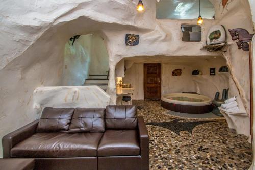 a living room with a leather couch in a cave at Adventure Suites in North Conway