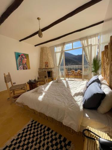 a bedroom with a large bed and a large window at KASBAH LA DAME BIJA in Tassa Ouirgane