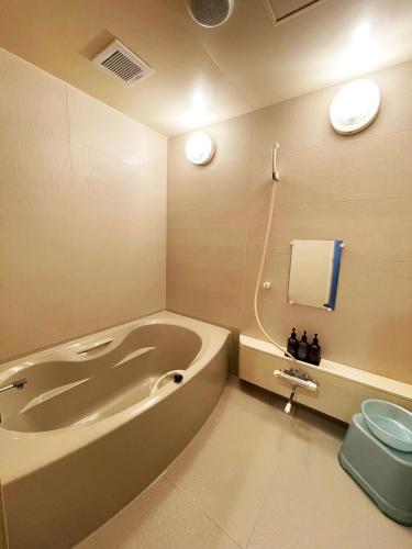 a bathroom with a tub and a toilet in it at Hotel ARUN-Adult Only in Abashiri