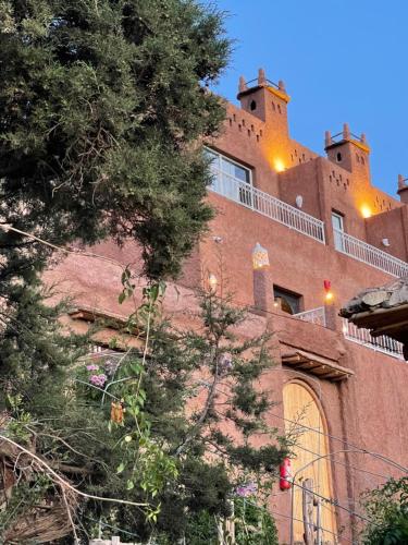 a large brick building with two towers on top of it at KASBAH LA DAME BIJA in Tassa Ouirgane