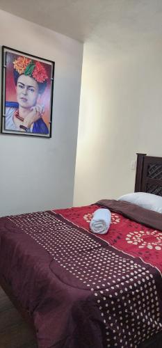 1 dormitorio con 1 cama con una foto de una mujer en Habitaciones Mimado morelia en Morelia