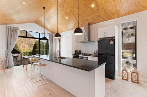 a kitchen with a black refrigerator and a counter at Little Alp Chalet in Queenstown