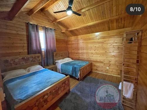 a bedroom with two beds in a log cabin at Villa encantadora pino alto J4 in Jarabacoa