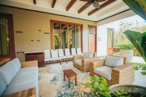 a living room with white chairs and a table at Hotel Bosque del Mar Playa Hermosa in Playa Hermosa