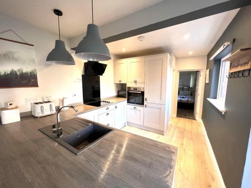 a kitchen with white cabinets and a sink at Belmont in Southampton