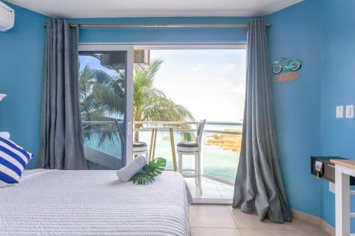 a bedroom with a bed and a view of the ocean at Cozy Beach Getaway - Lux Studio next to The Morgan Village in Maho Reef