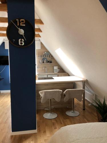 a kitchen with a clock on the wall and two stools at Loft Johanns Hochsitz in Beverungen