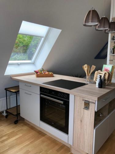 a kitchen with a stove top oven next to a window at Loft Johanns Hochsitz in Beverungen