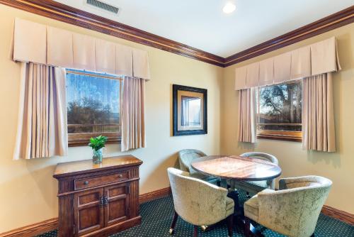 a dining room with a table and chairs and windows at Stock Farm Inn in Hopland