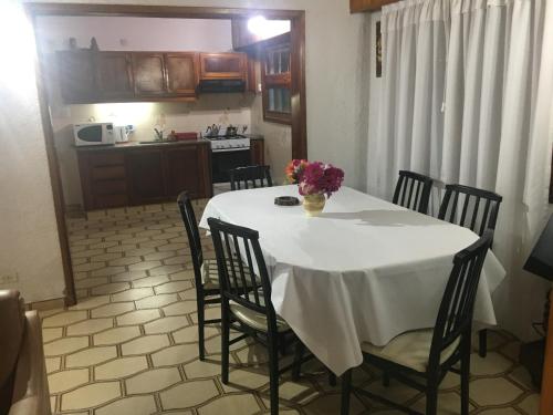 una mesa blanca con sillas y un jarrón de flores. en Casa Navia en Ostende