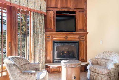 a living room with two chairs and a fireplace at Stock Farm Inn in Hopland