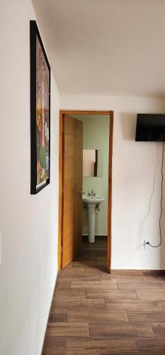 a hallway with a door and a sink in a room at Habitaciones Mimado morelia in Morelia