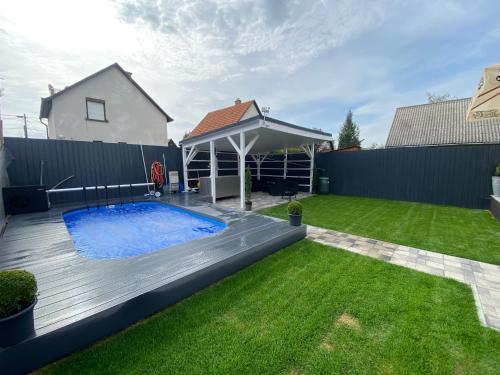 a backyard with a swimming pool and a fence at Nemes Apartmanház Tóalmás in Tóalmás