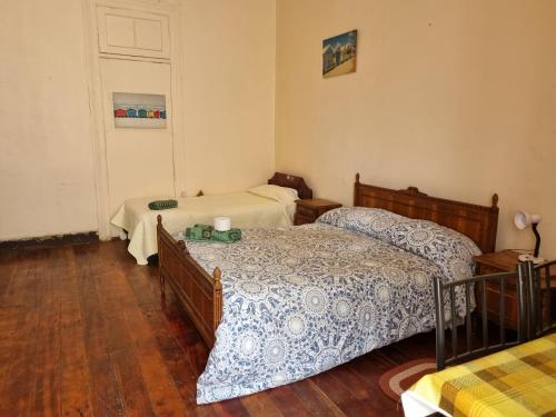 two beds in a room with wooden floors at HOSTAL PLAYA ANCHA in Valparaíso