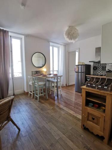 cocina y comedor con mesa y sillas en Appartement dans une villa au cœur de la ville, en Barcelonnette