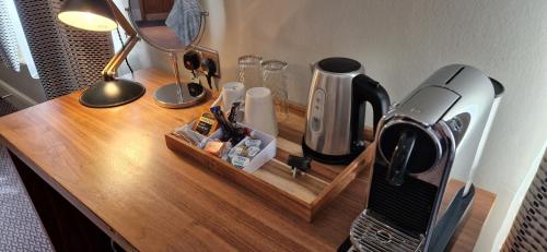 a wooden table with a coffee maker on it at The Cross-Keys Hotel in Knutsford