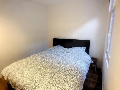 een slaapkamer met een wit bed met een zwart hoofdeinde bij Appartement 003 in Angleur