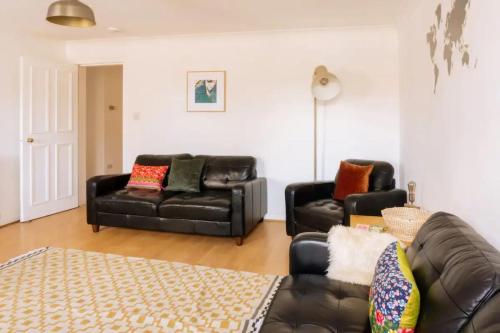 a living room with two leather couches and a rug at Charming 3 Bedroom Apartment in the Heart of Vibrant Old Town in Edinburgh