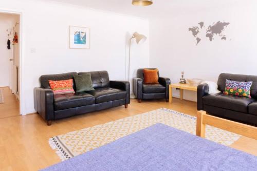 a living room with two leather couches and a table at Charming 3 Bedroom Apartment in the Heart of Vibrant Old Town in Edinburgh