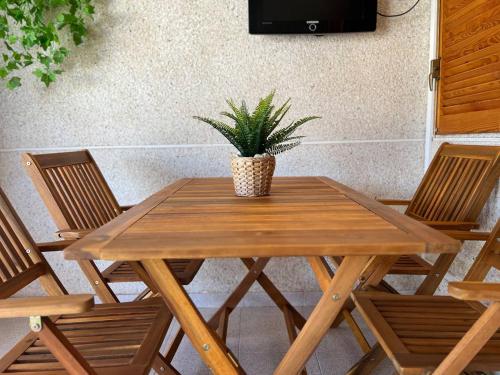 einem hölzernen Picknicktisch mit einer Topfpflanze darauf in der Unterkunft Acogedor apartamento a escasos metros de la playa in Santa Pola