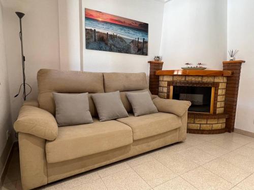 ein Sofa im Wohnzimmer mit Kamin in der Unterkunft Acogedor apartamento a escasos metros de la playa in Santa Pola