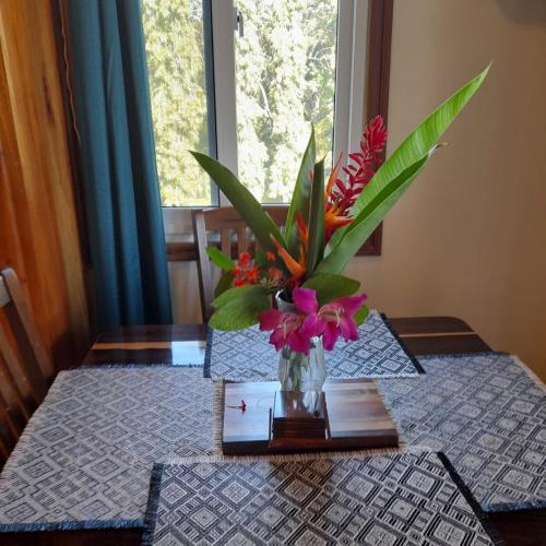 a table with a vase of flowers on a table at Belize Bay Estate in Punta Gorda