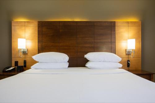 a bedroom with a large bed with three pillows at Arroyo Pinion Hotel, an Ascend Collection Hotel in Sedona